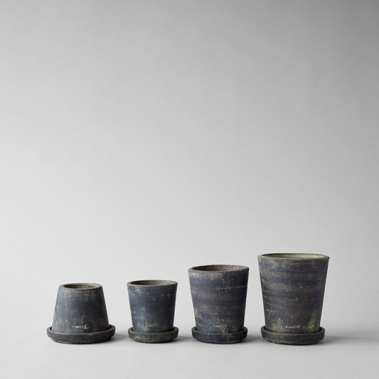 Set of four small planter pots in grey patina with flared rims