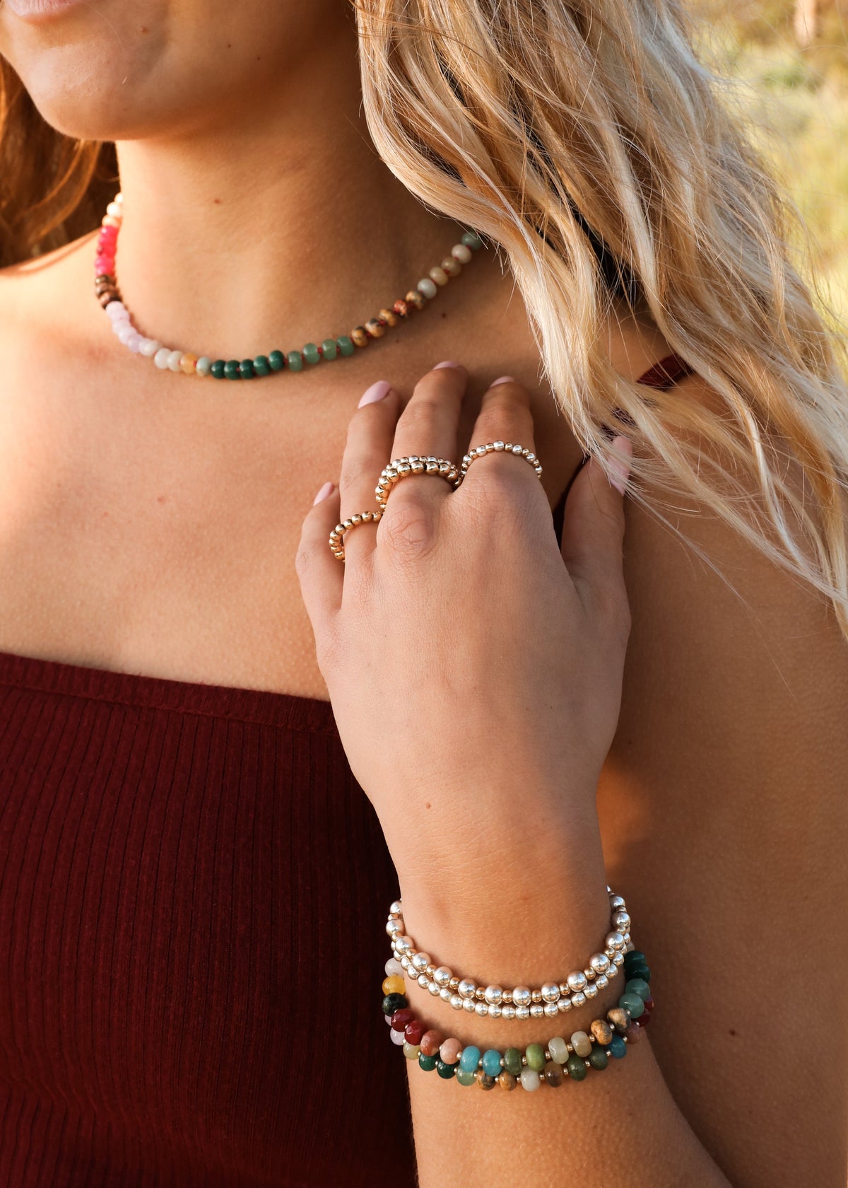 Multicolor gemstone beaded necklace and gold toggle clasp, close-up on neckline