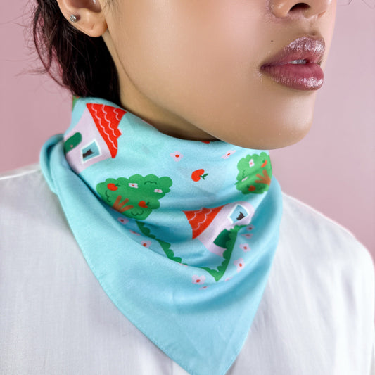 Light blue cotton-silk bandana worn at neck with red house and green tree print