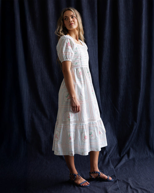 White midi dress with puff sleeves, square neckline, smocked waist and tiered skirt