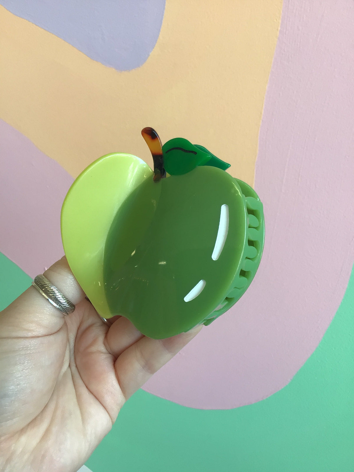 Green apple fruit hair claw with leaf detail and white comb teeth