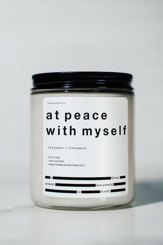 Lavender and cinnamon scented candle jar with black screw-top lid and label.