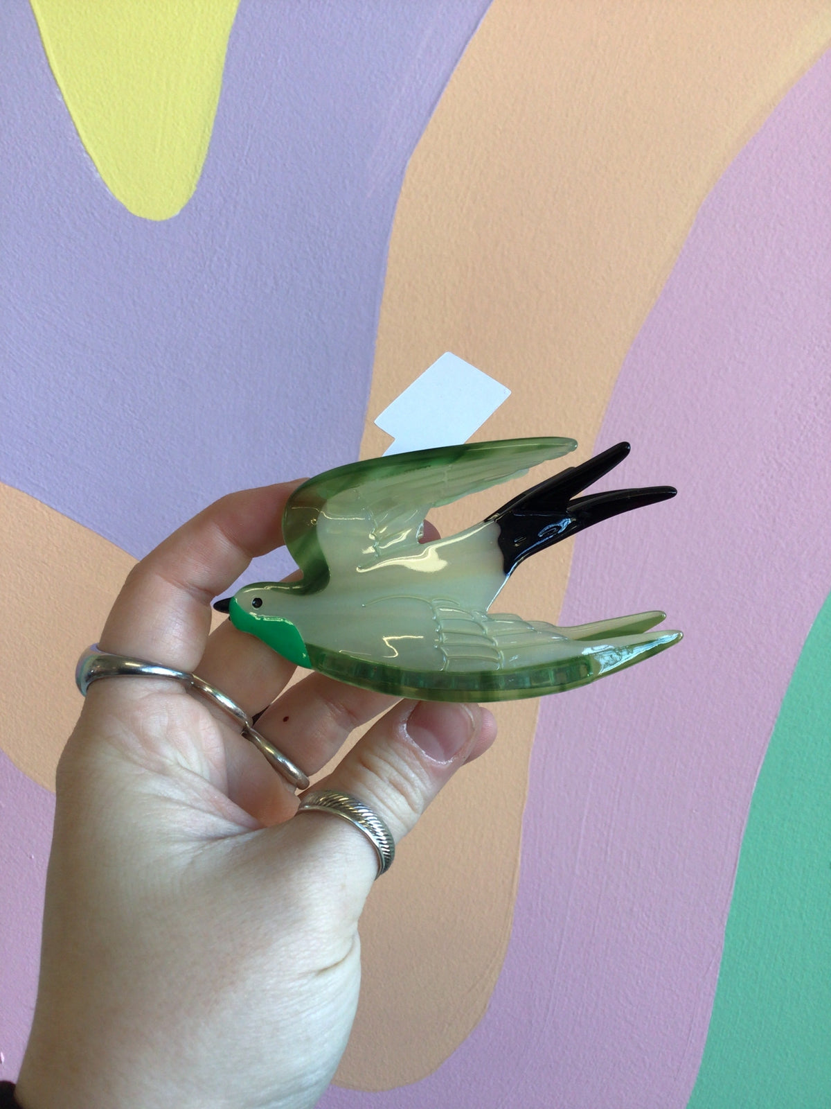 Green swallow hair claw with translucent wings and two-prong snap clip