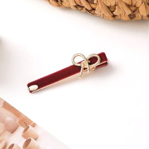 Deep red velvet hair clip with gold bow detail