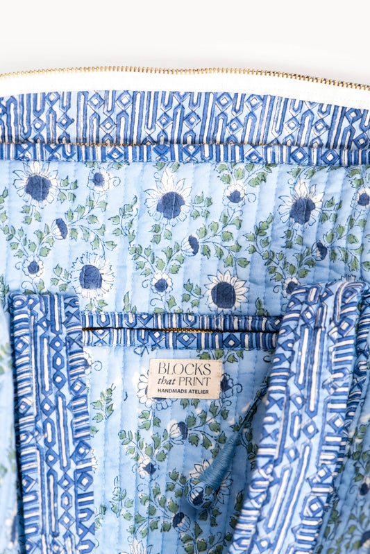 Block print quilted duffle bag panel with blue trim and central brand label