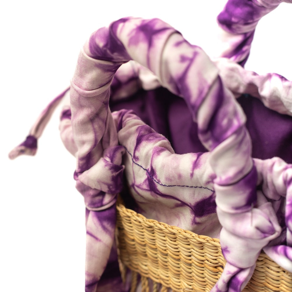Mini woven bag close-up showing purple tie-dye lining and stitched strap details
