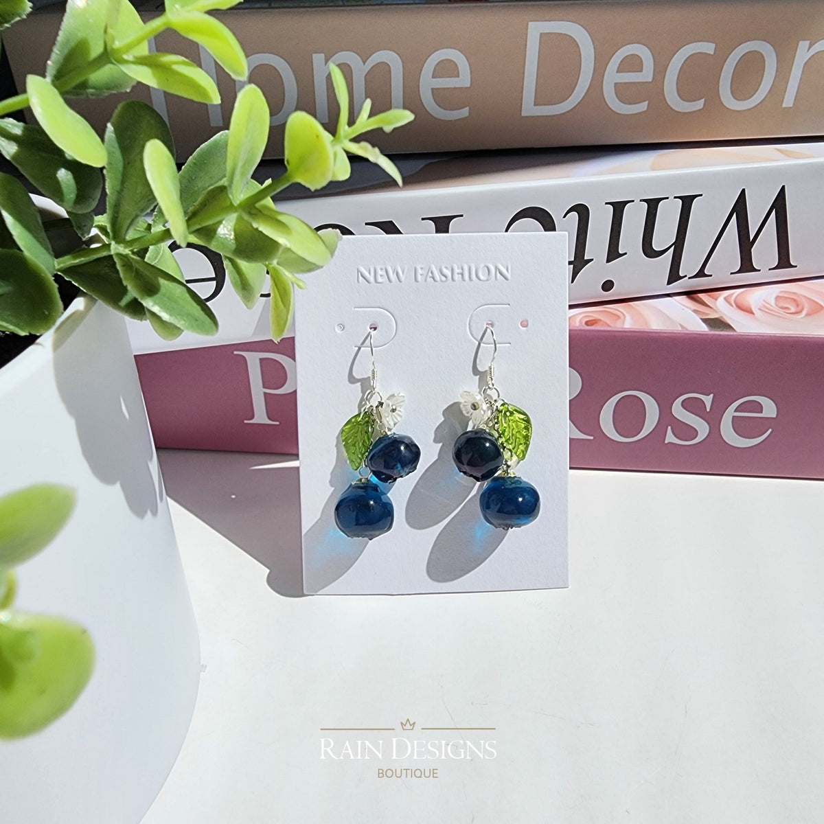 Resin blueberry cluster dangle earrings with blue berries and green leaf accents