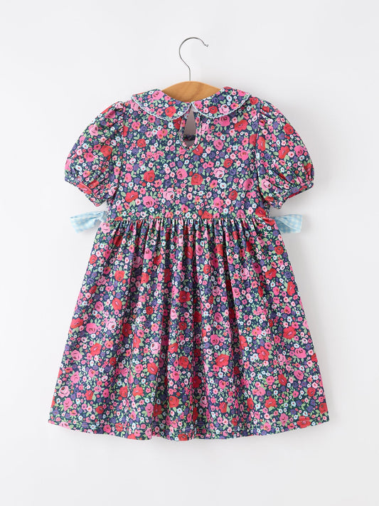 Girls floral dress with short puff sleeves, smocked bodice, and blue ribbon bows