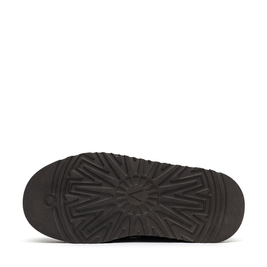 Dark rubber slipper sole with a raised radial tread pattern