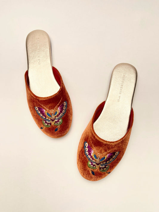Pair of burnt orange velvet mules with butterfly embroidery, cream insoles