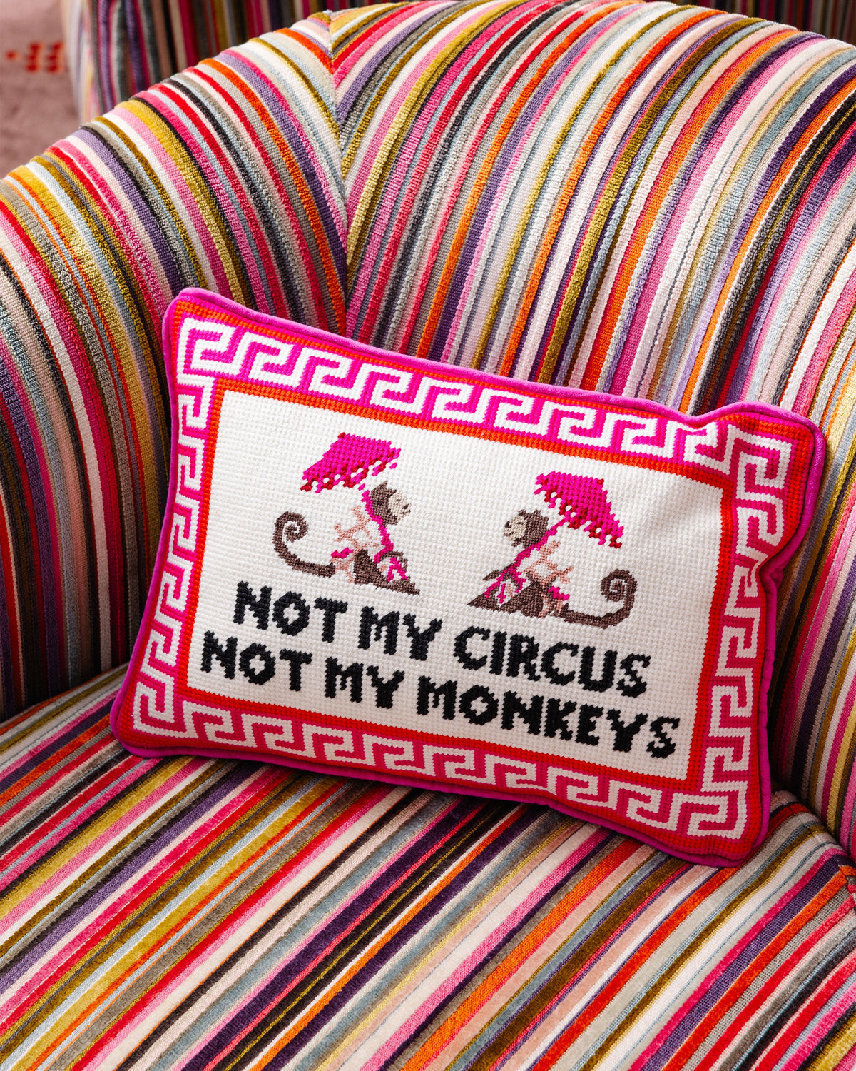 Needlepoint throw pillow with Greek key frame, monkeys motif, and "Not my circus" text
