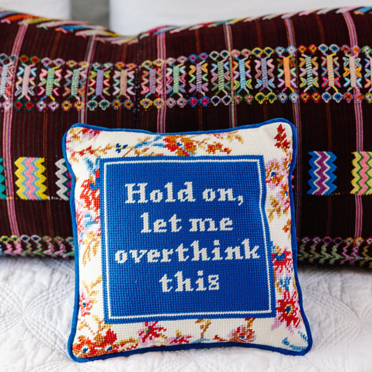 Needlepoint throw pillow with blue embroidered quote panel and multicolor floral edging