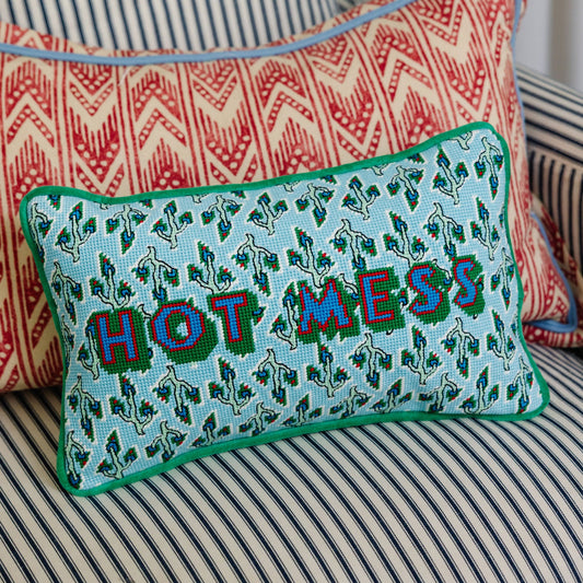 Light blue needlepoint lumbar pillow with green border and 'HOT MESS' lettering