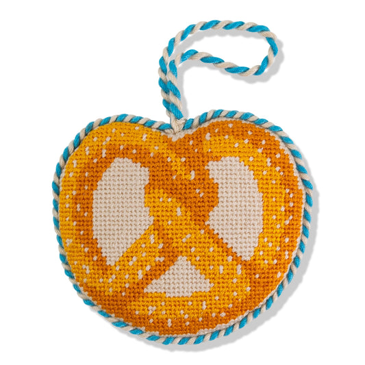 Needlepoint pretzel icon ornament with orange and white pattern, blue stitched border and loop