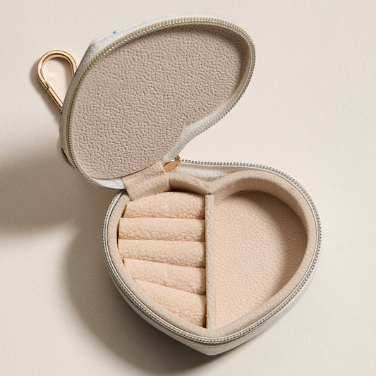 Heart-shaped jewelry travel case open with beige interior compartments