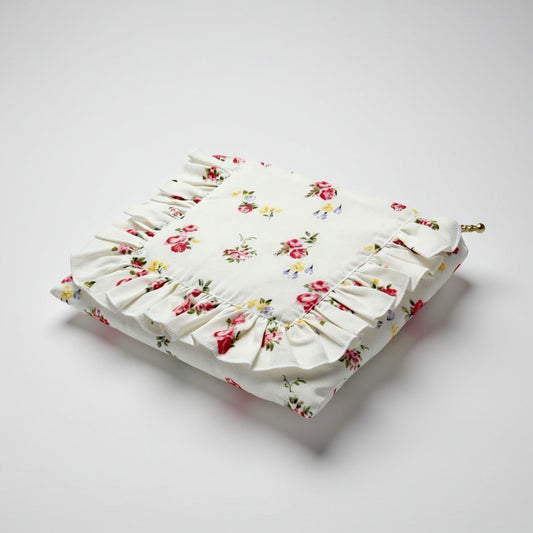White floral ruffle zipper pouch, angled view with brass zipper pull