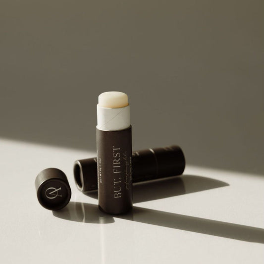 BUT, FIRST perfume priming balm tube with cap removed and balm disk end