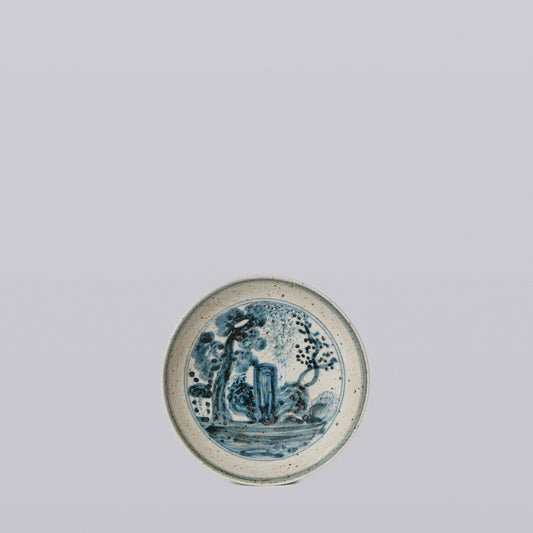 Blue and white porcelain round dish with cobalt illustrated scene and speckled glaze