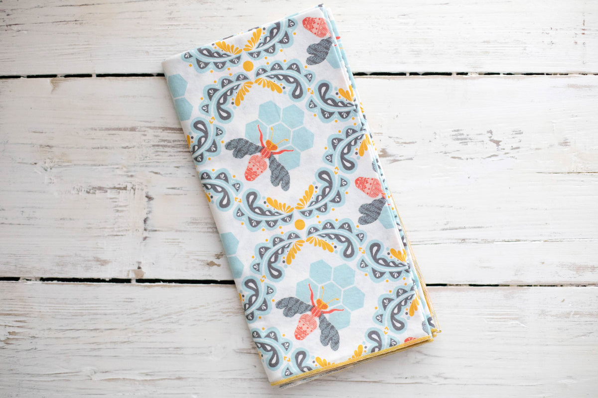 Bee and honeycomb print cloth napkin, light blue with gray and orange accents