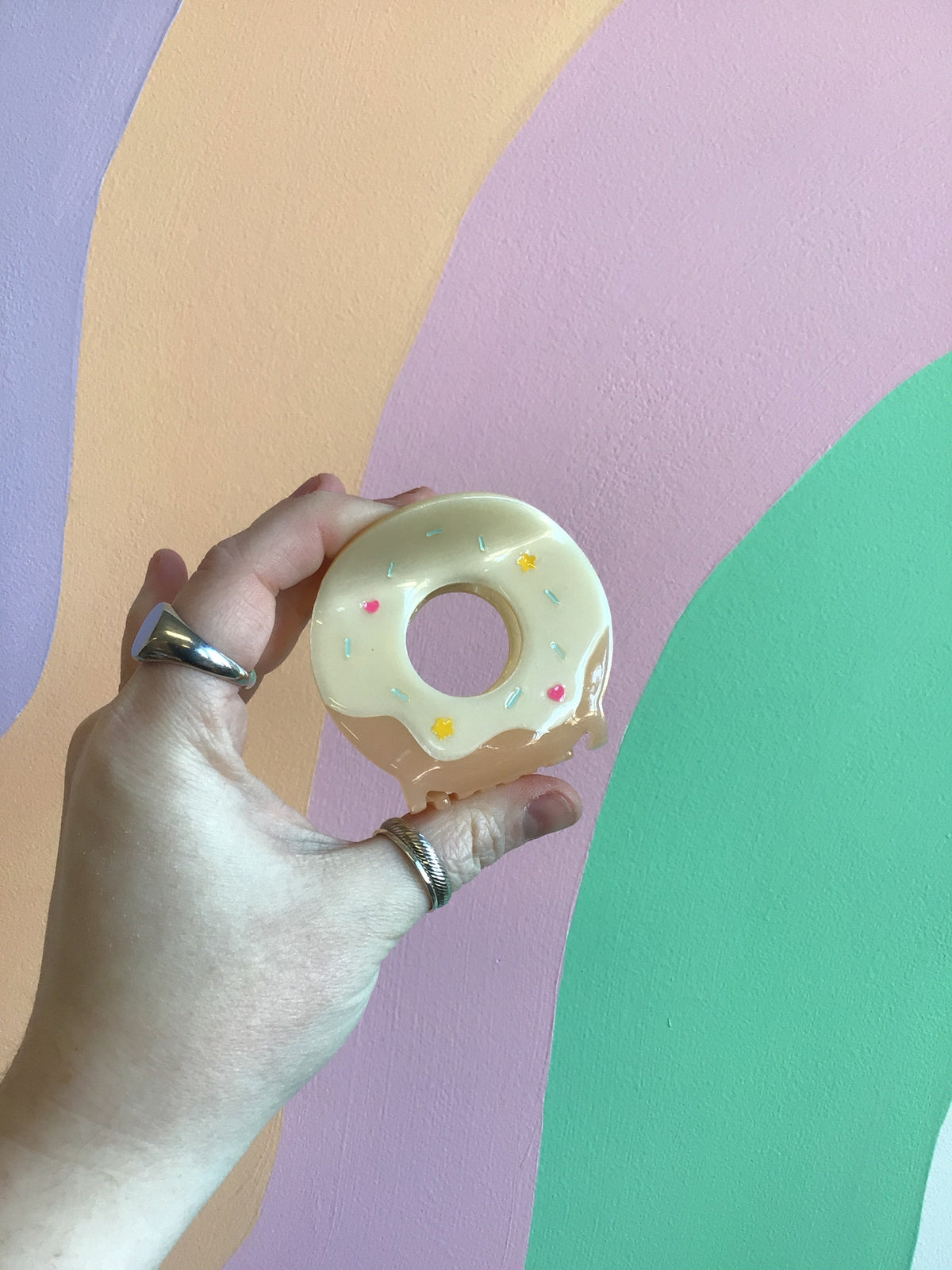 Donut-shaped hair claw with cream frosting and pastel sprinkle details