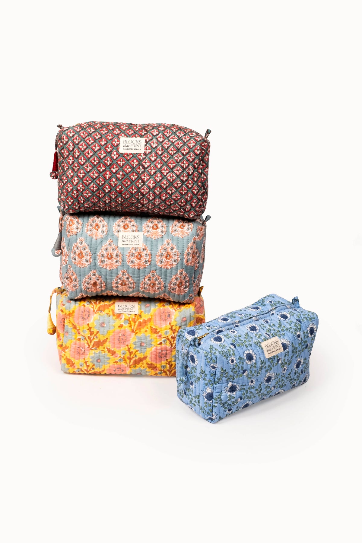 Set of quilted travel pouches, stacked floral block prints in orange and blue