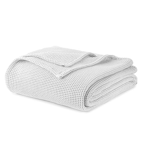 White waffle-knit blanket, neatly folded roll with textured waffle weave.