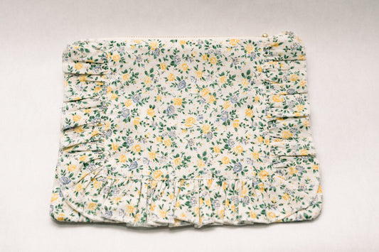 Cream floral zipper pouch with ruched ruffle trim and gold zipper pull at top.