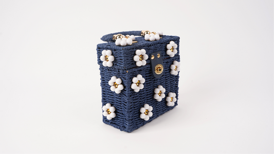 Navy woven mini tote bag angled view with white flower details and gold hardware