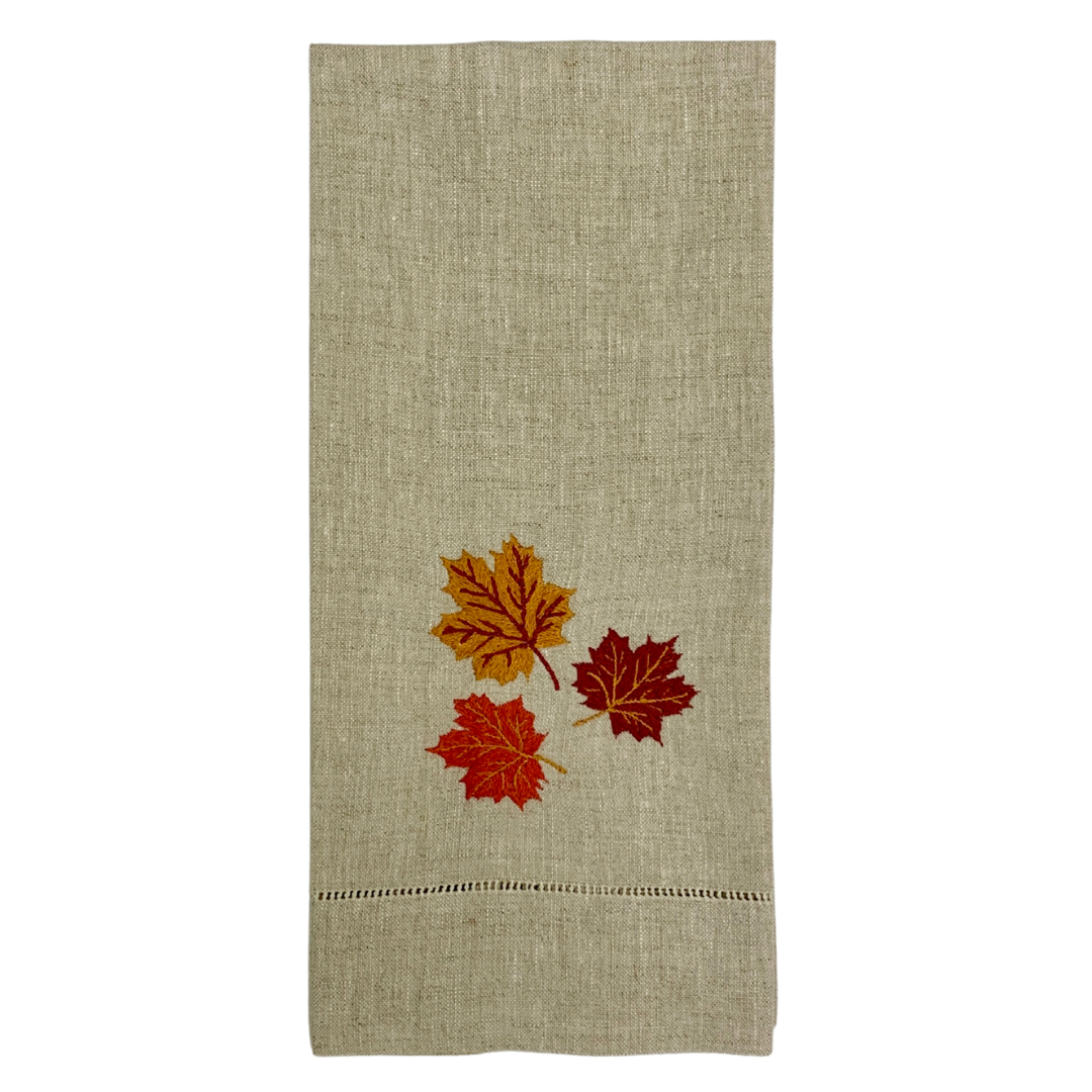 Tea towel in light beige with three embroidered autumn leaves and small stitched hem