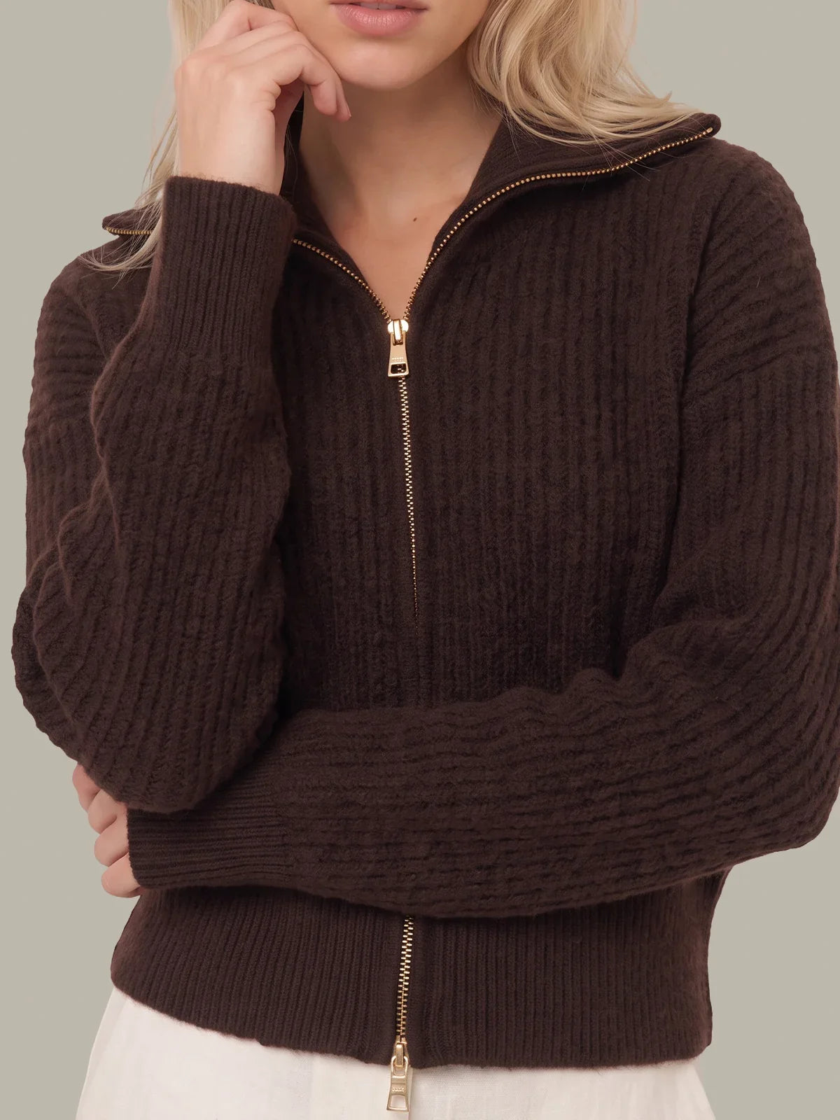 Cropped fuzzy zip-up jacket close-up with gold zipper pull and ribbed collar