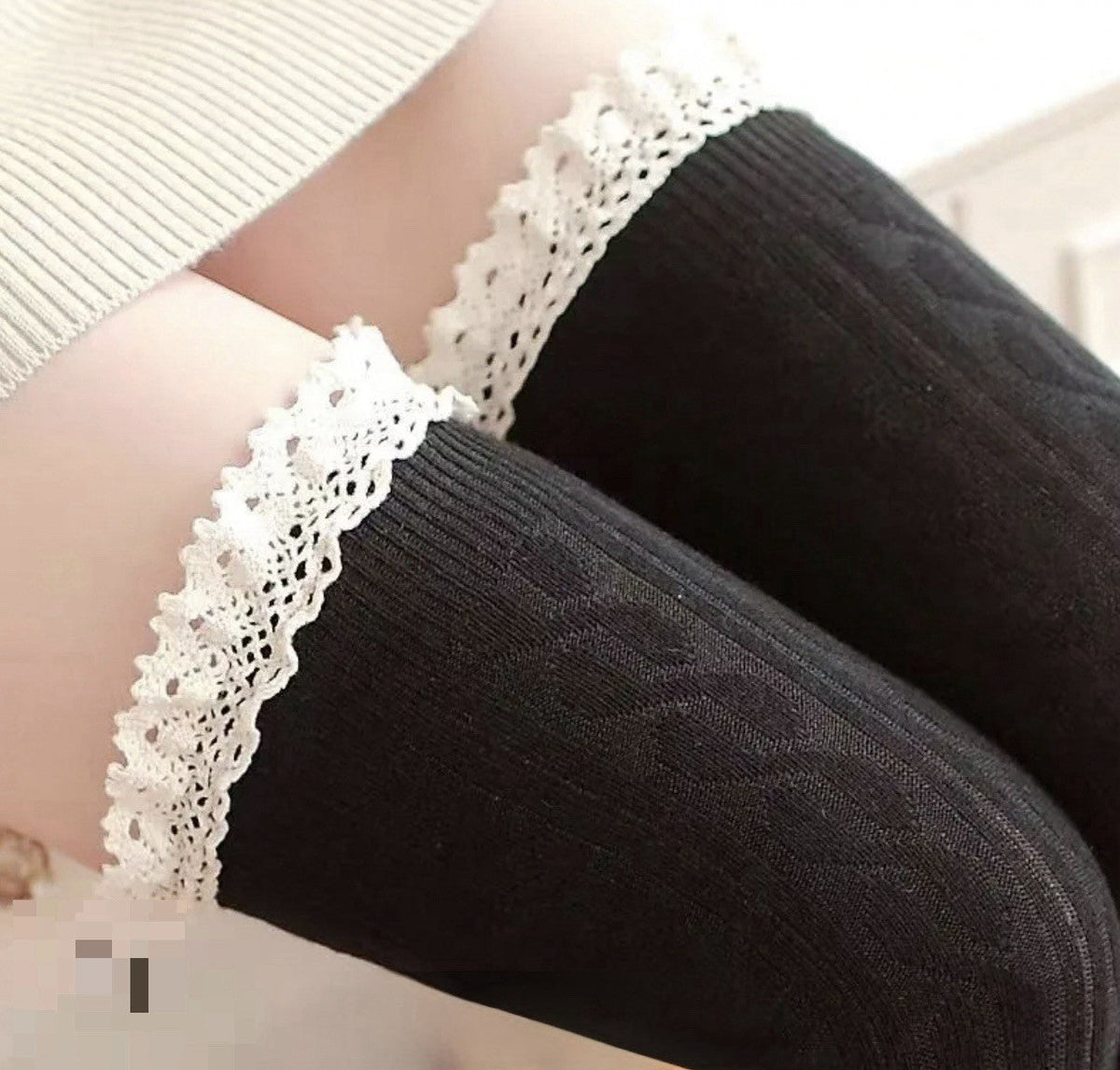 Black knee-high cable knit socks with white lace cuff trim