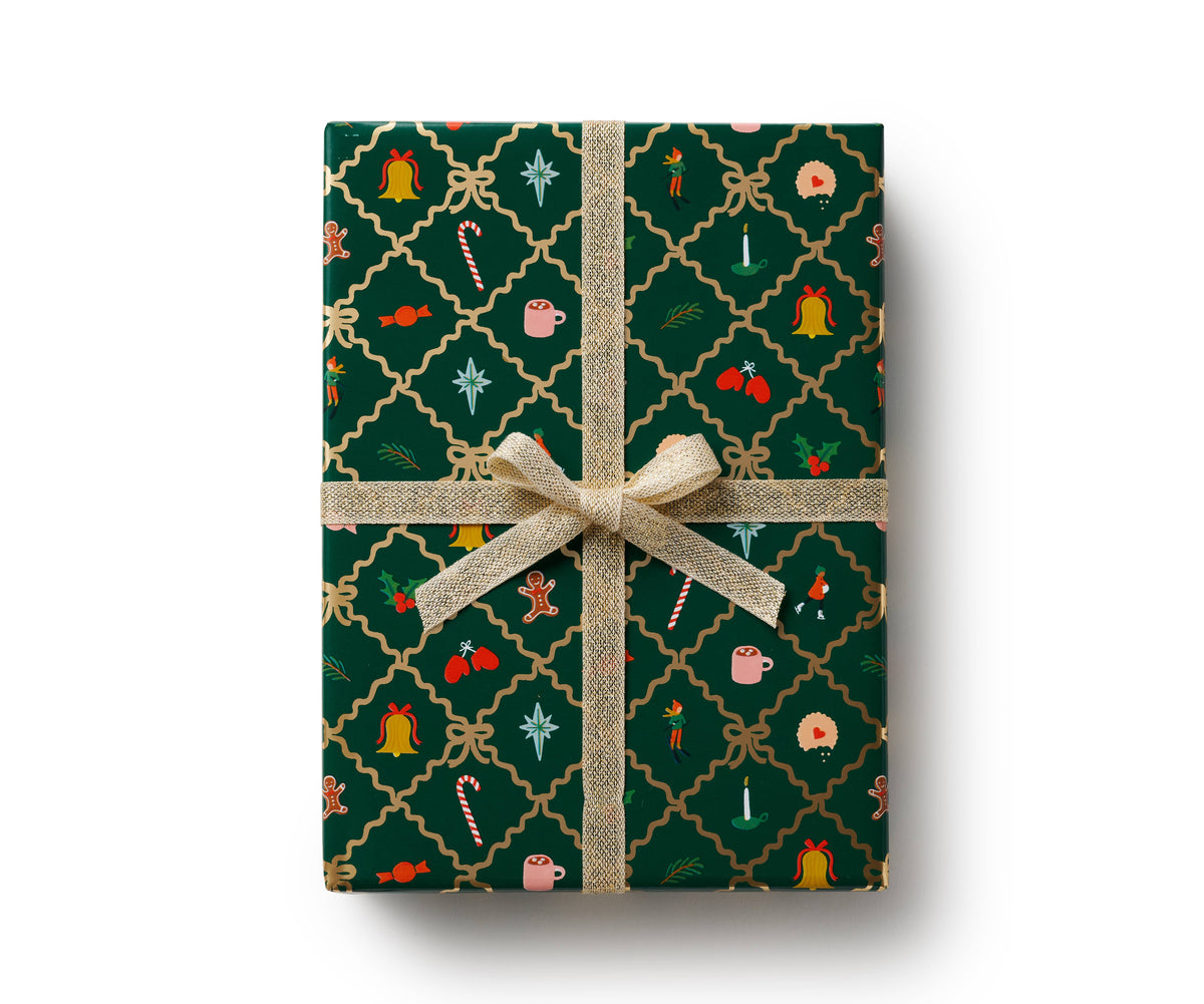 Holiday gift wrapping paper with green gingerbread and holly pattern, tied with gold ribbon bow