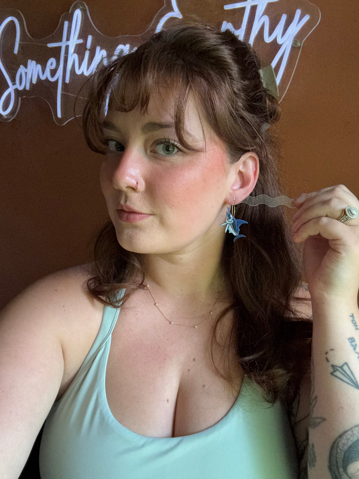 Blue marlin fish drop earrings on a model, visible dangling charms