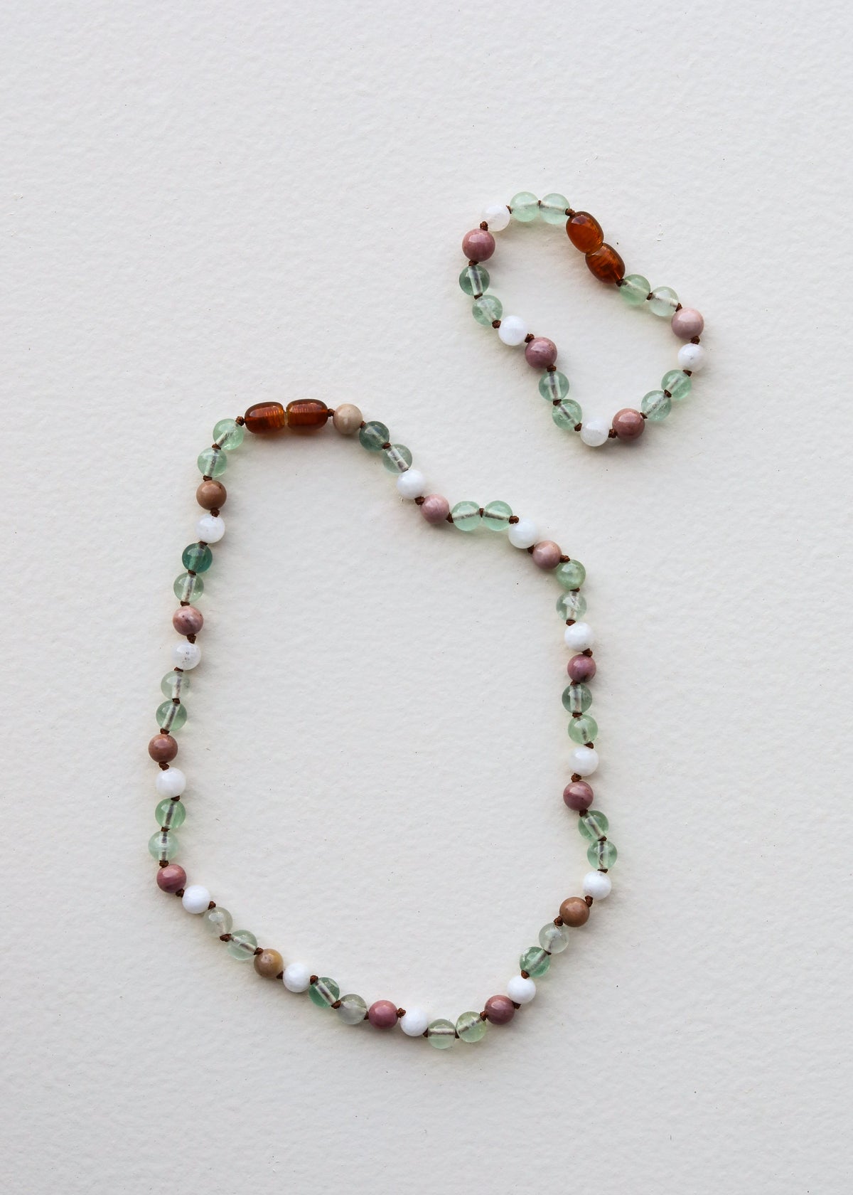 Two gemstone beaded bracelets with green, pink, white beads and amber center sections