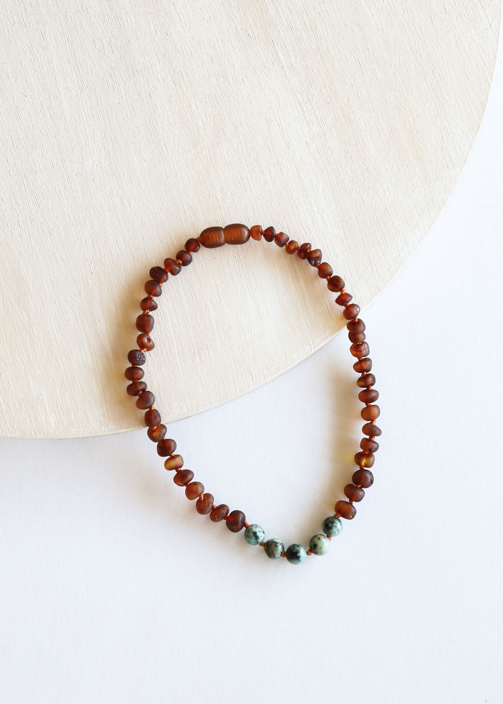 Red-brown beaded necklace with small turquoise jasper accent beads