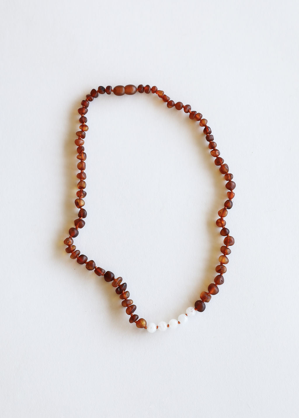 Brown amber bead necklace with small white moonstone beads, oval loop