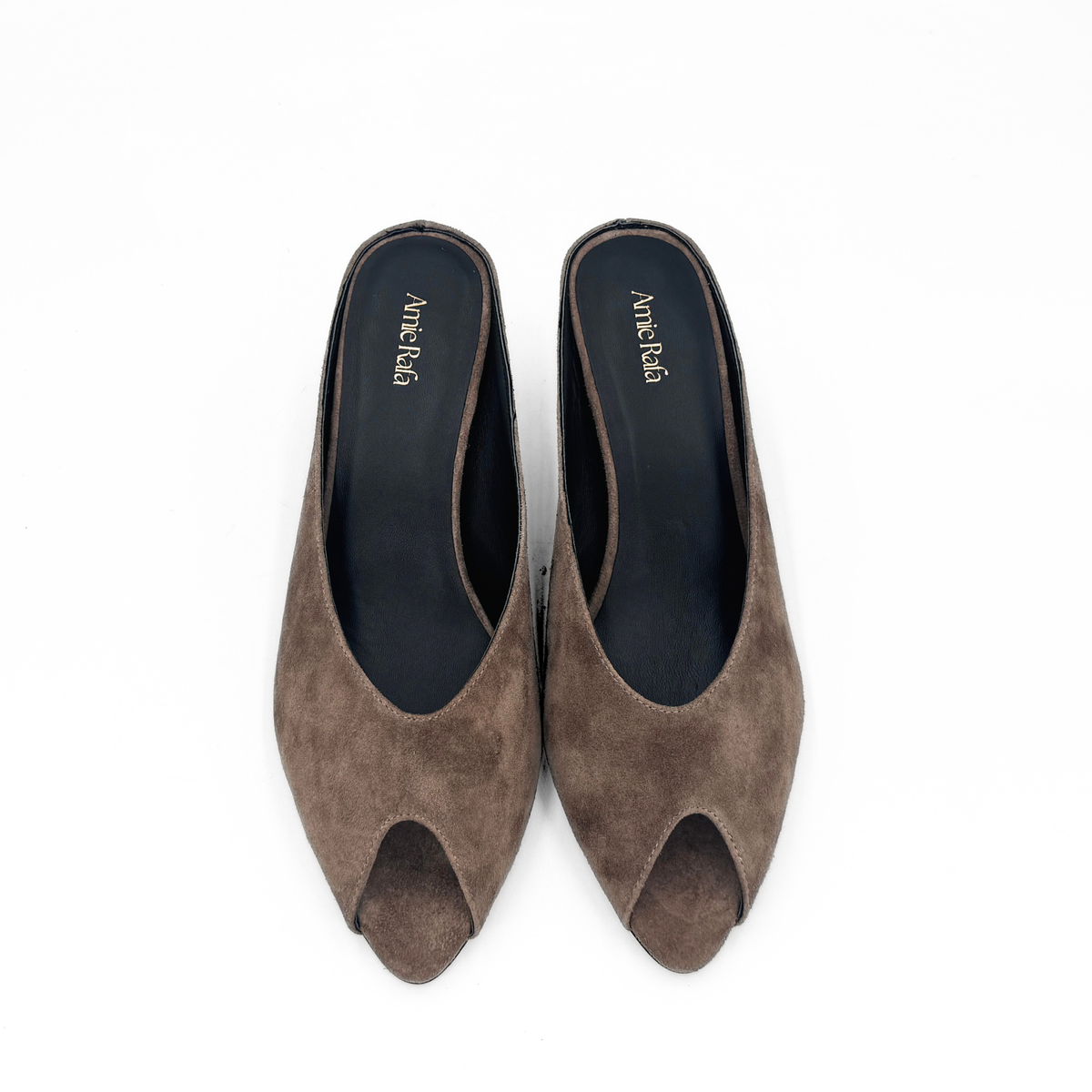 Brown suede peep-toe mules with navy-lined interior and open toe