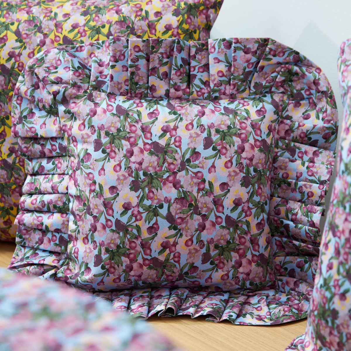 Close-up ruffled pillow cover, pink and purple flower print with pleated panel