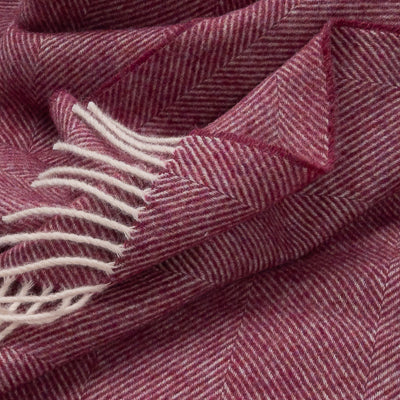 Berry herringbone throw close-up with cream fringed edge and textured weave