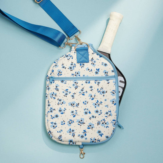 Blue floral paddle bag with front zip pocket, shoulder strap, and paddle handle visible