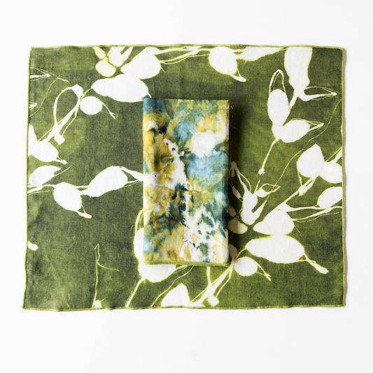 Olive green placemat with white floral vine print, card placed in center