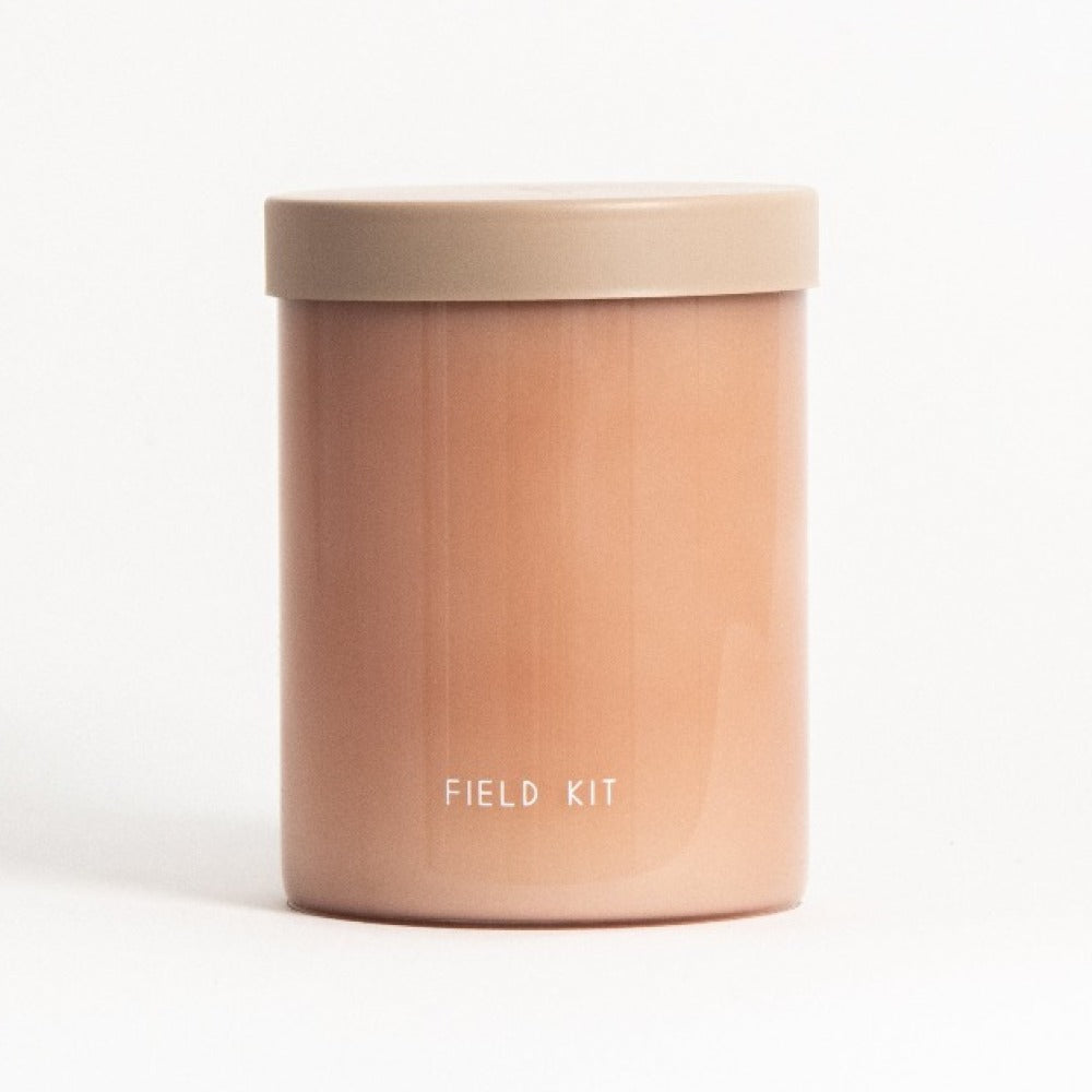 Amber jar candle with tan lid and 'FIELD KIT' print on front