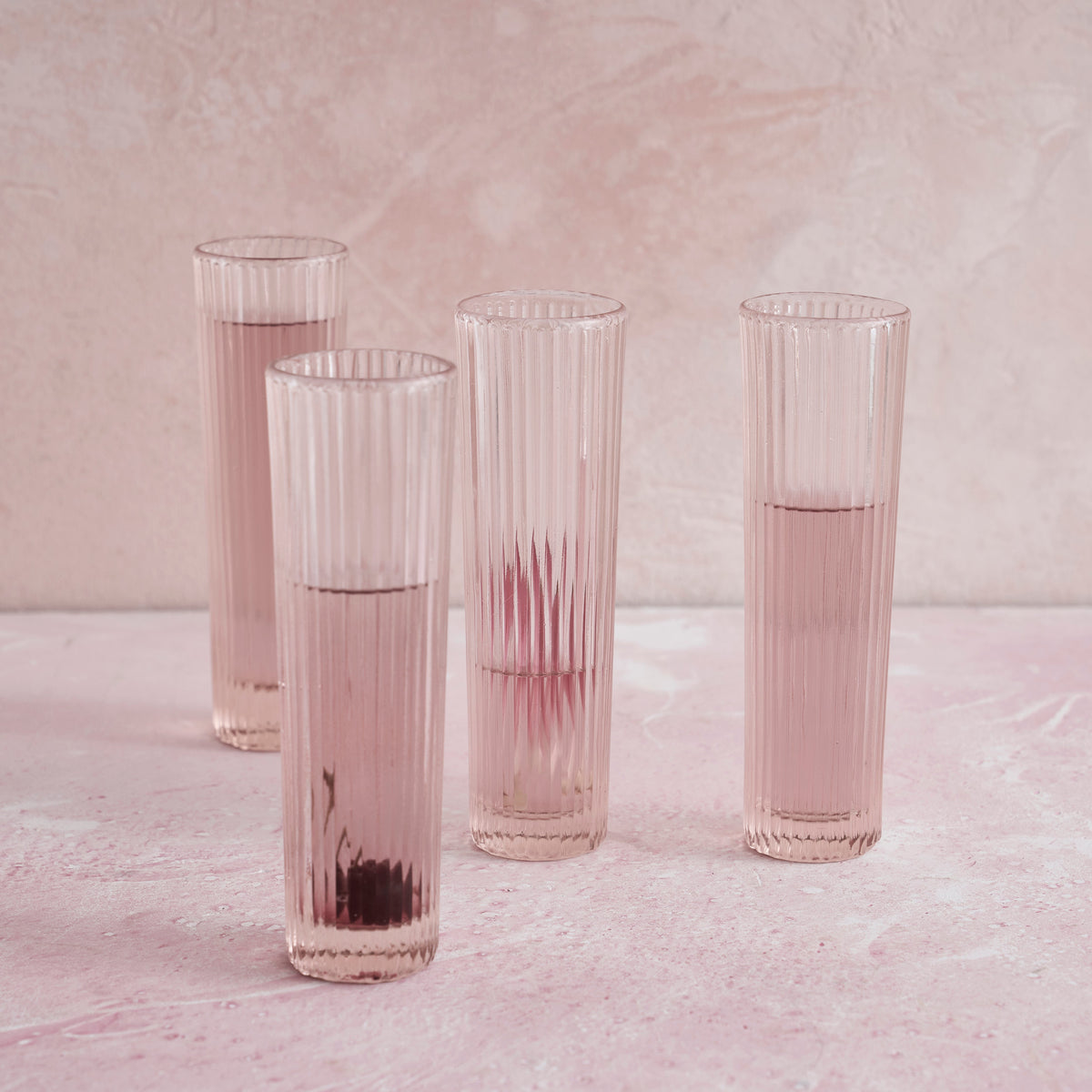 Set of 4 pressed pink champagne flutes with vertical ridges and rounded rims