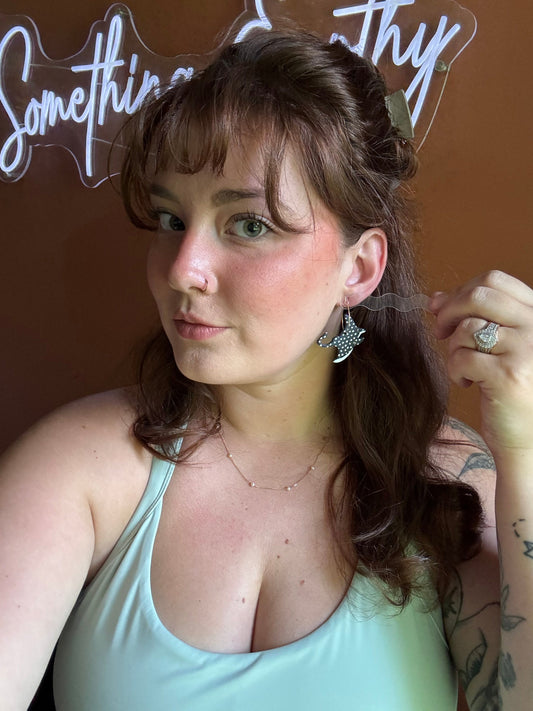 Stingray hoop earrings with speckled black-and-white wings, worn by model