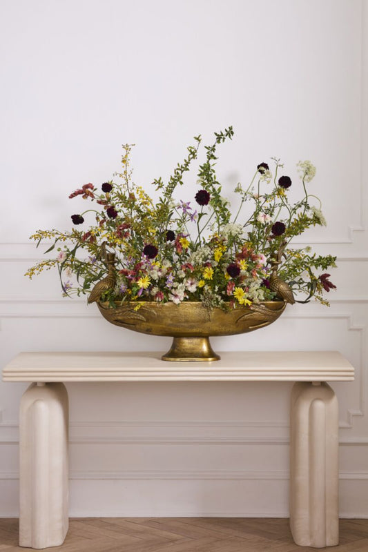 Decorative gold-tone footed bowl floral centerpiece with abundant mixed flowers