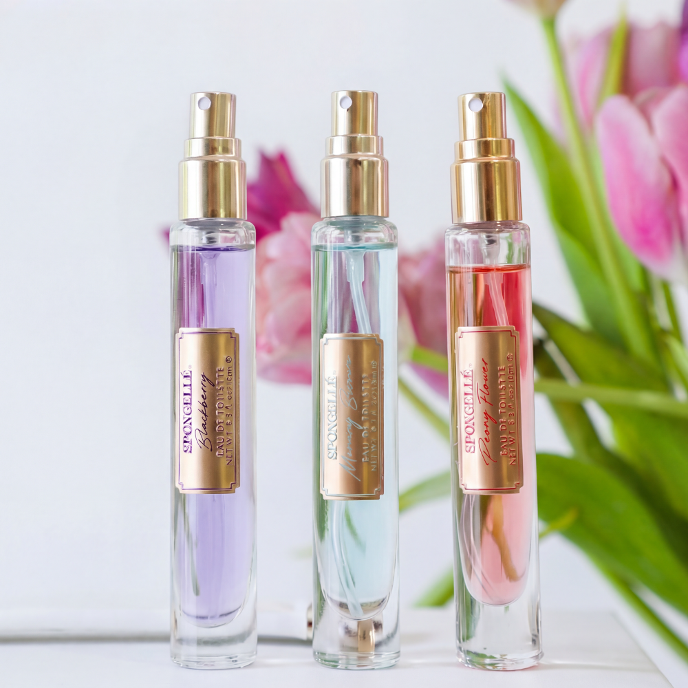 3 spray eau de toilette bottles in purple, green, and pink with gold mist nozzles