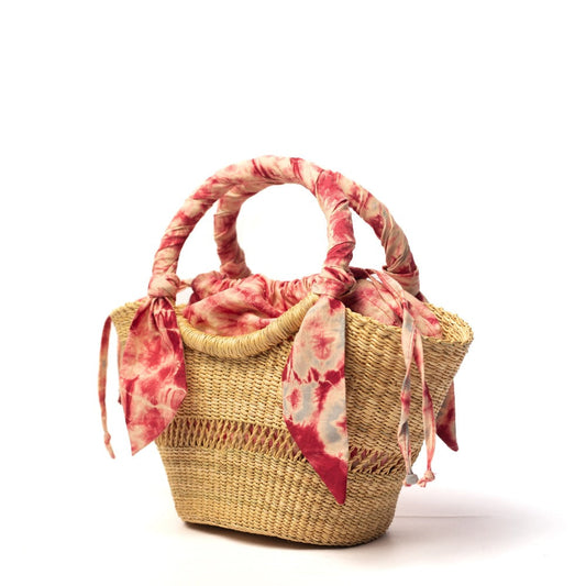 Small woven straw bag with red tie-dye scarf bows and open top