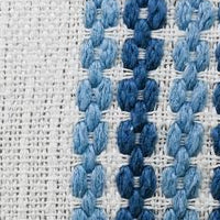 Close-up of woven pillow fabric: repeating blue looped motif on off-white background