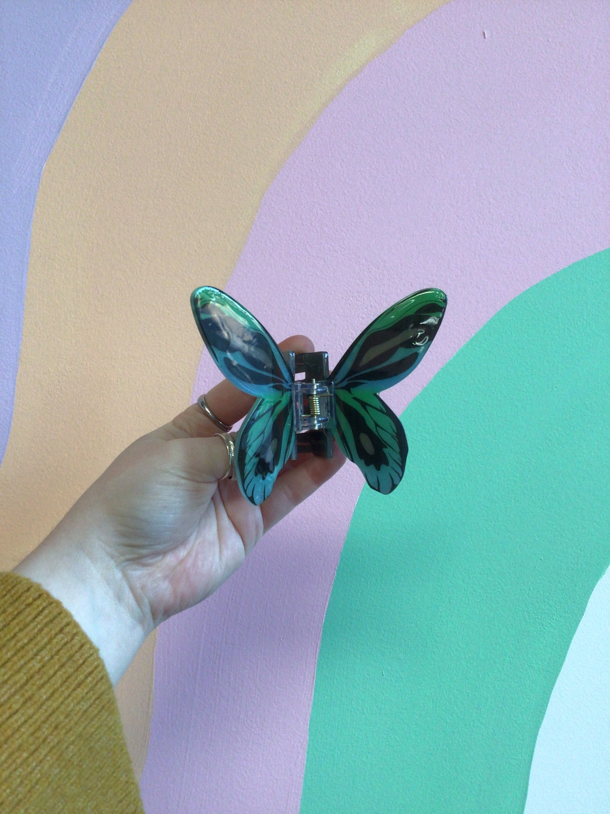 Teal and blue butterfly hair claw clip with glossy wings and central hinge.