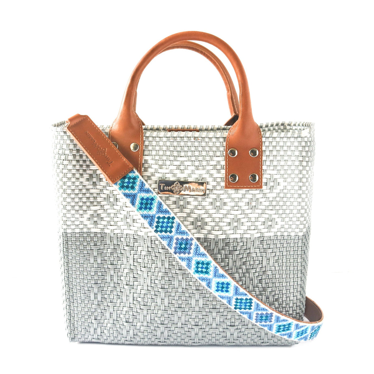 Woven bag strap with blue patterned webbing and tan leather ends, rivets